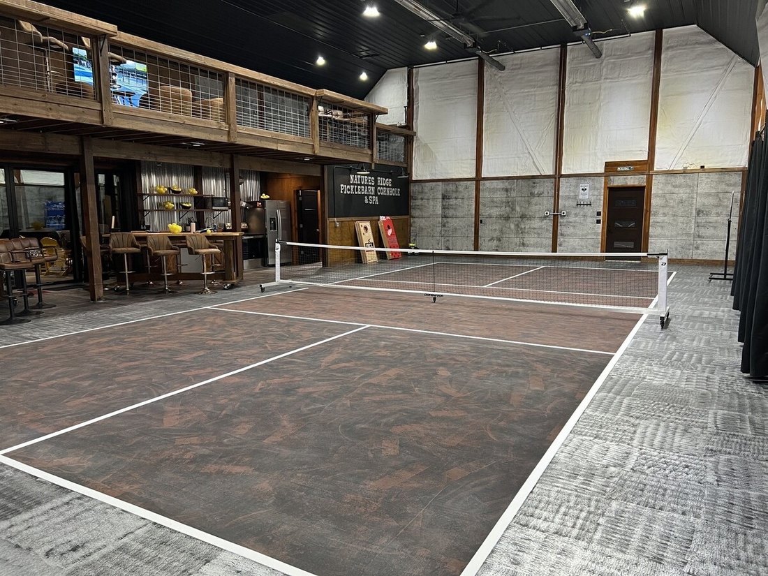 Indoor pickleball court with lounge and bar